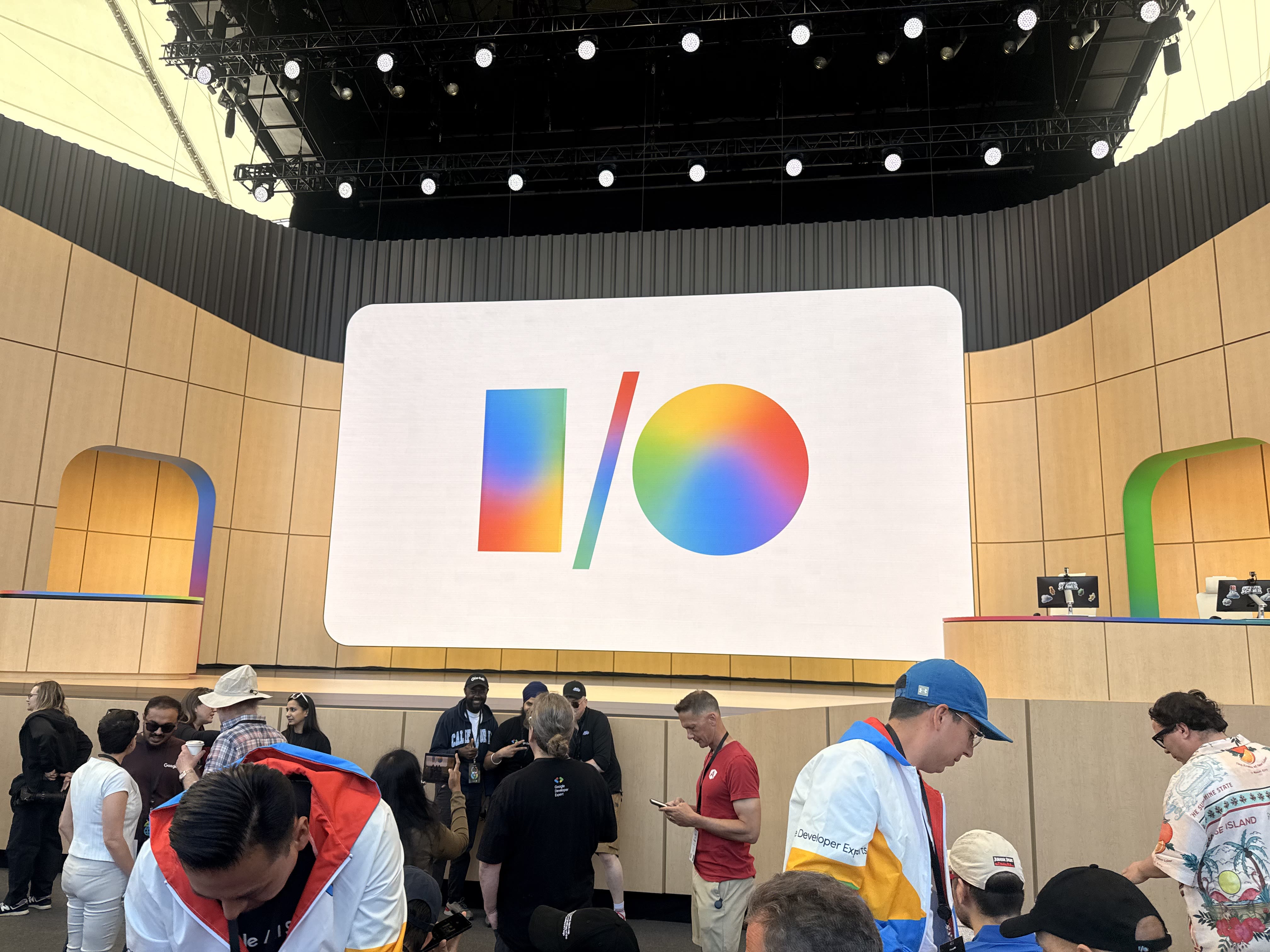The Google I/O 2026 logo on the main stage at Shoreline Amphitheatre with attendees in the foreground.