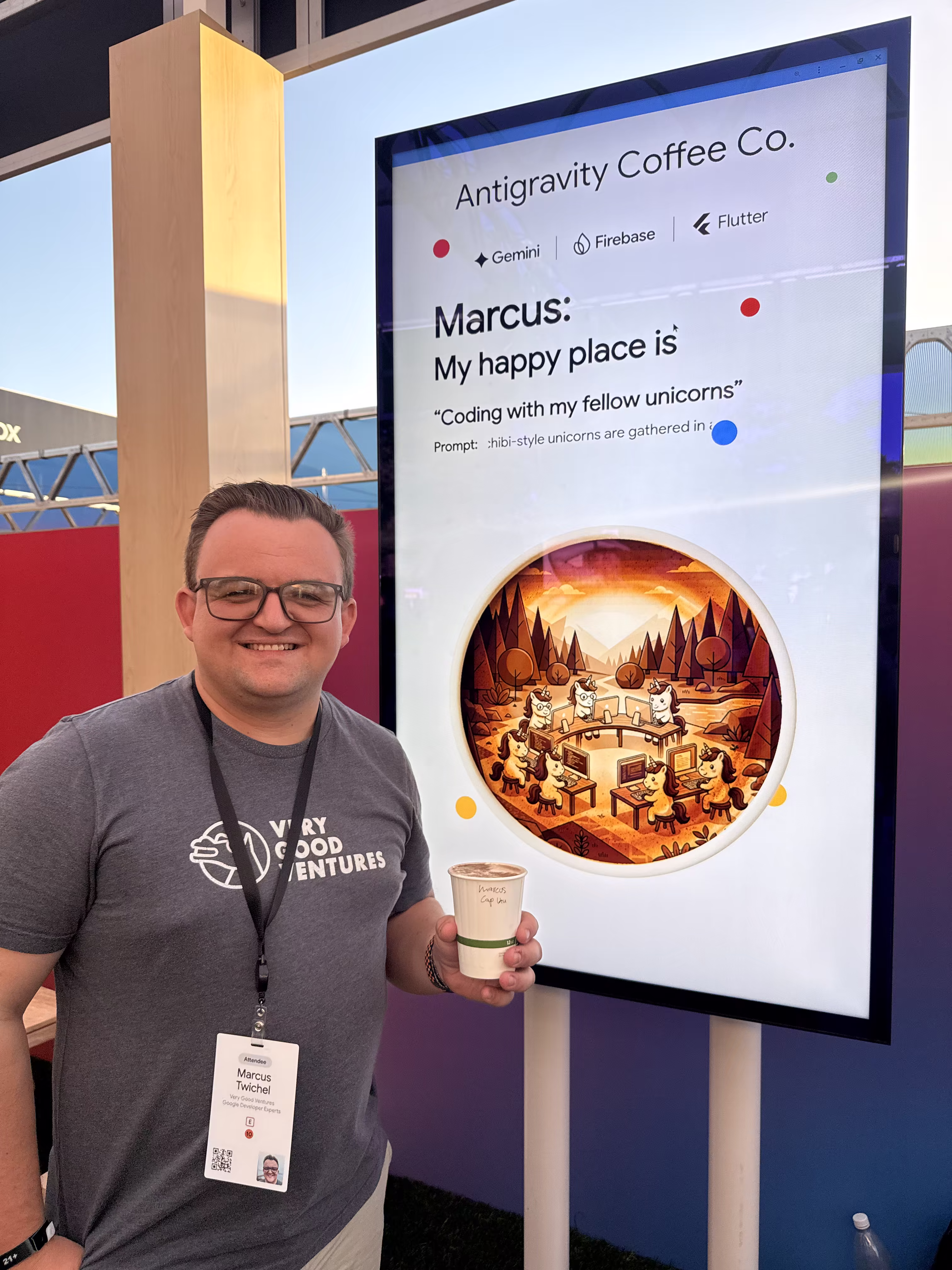 Marcus with the Antigravity Coffee Co. display showing the prompt "My happy place is: Coding with my fellow unicorns."